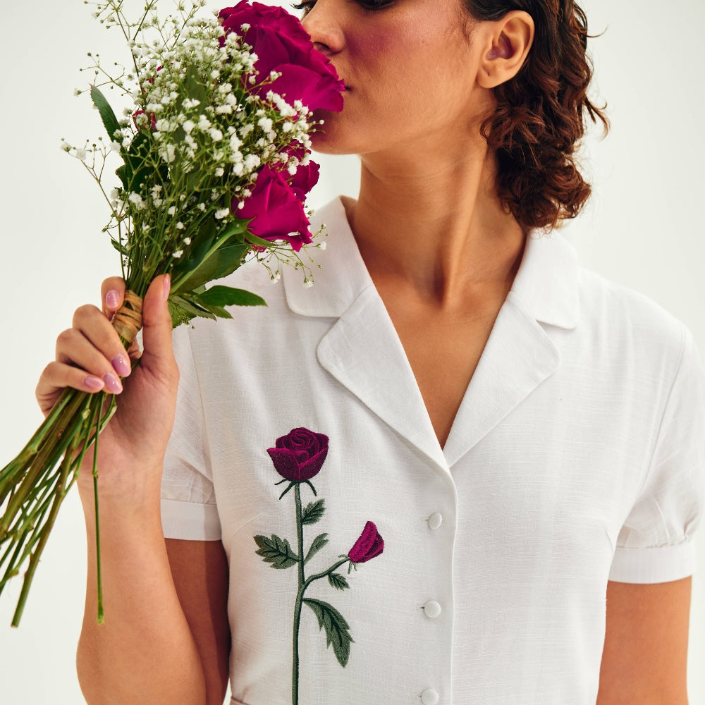 Model in Collared Shirt, Red Rose Design, Enjoying the Fragrance of Fresh Blooms.