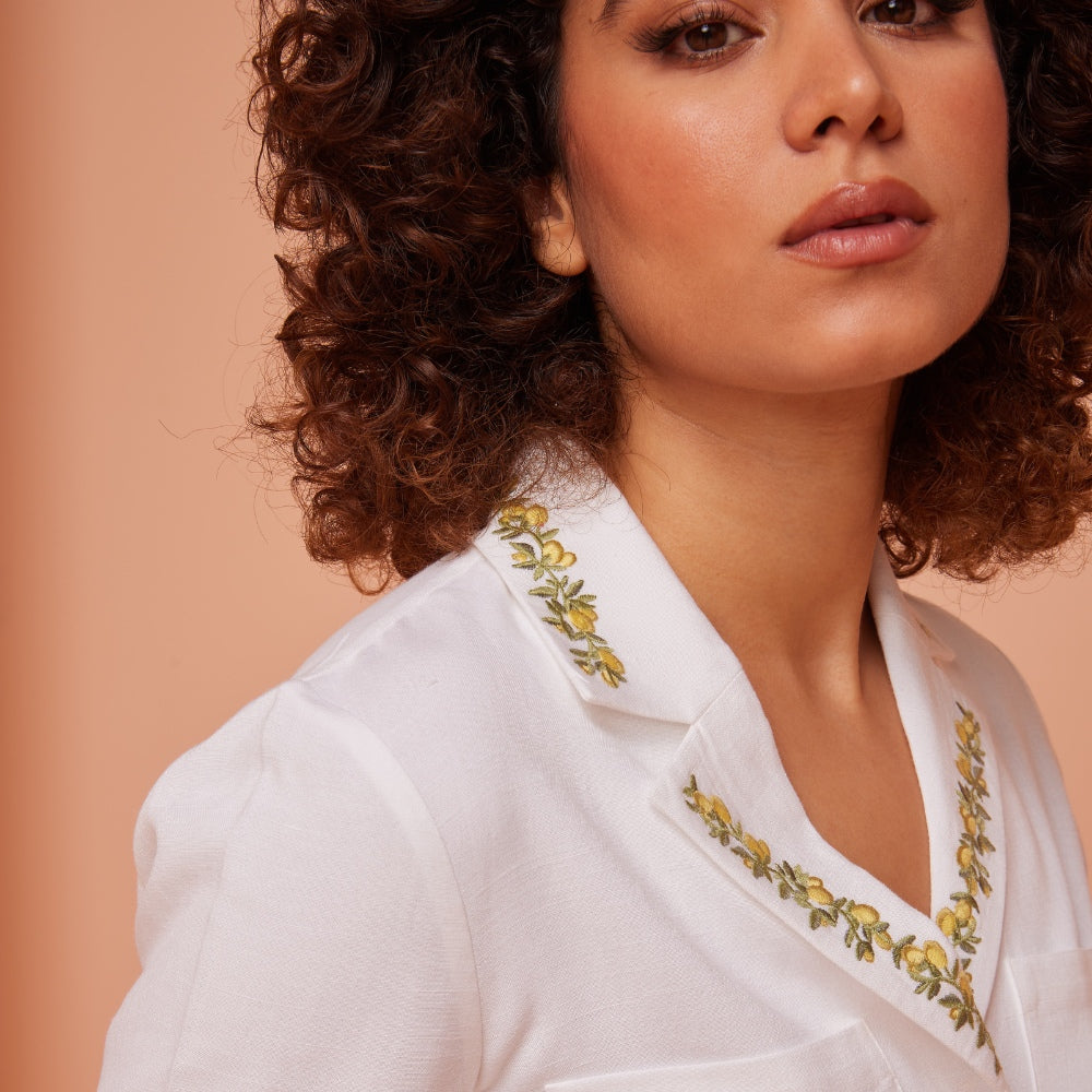 White Linen Dress with Radiant Yellow Leaf Embroidery Adorning the Collar.